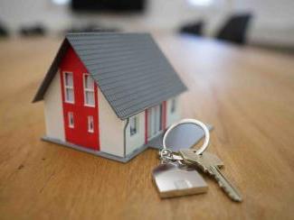 Set of keys beside miniature house